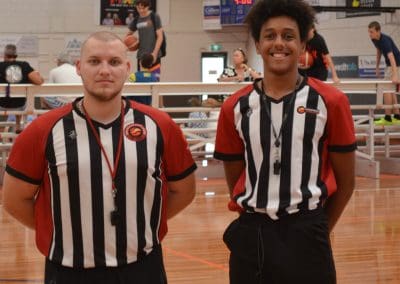 Suncoast Clippers Basketball Clippers Basketball Refs two referees standing on court smiling scaled