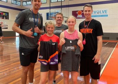 Suncoast Clippers Basketball Clippers Basketball September Camp young women with coaches holding uniform gym court scaled