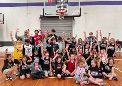 Suncoast Clippers Basketball Clippers Basketball camps young players and coaches hands raised posing for photo scaled